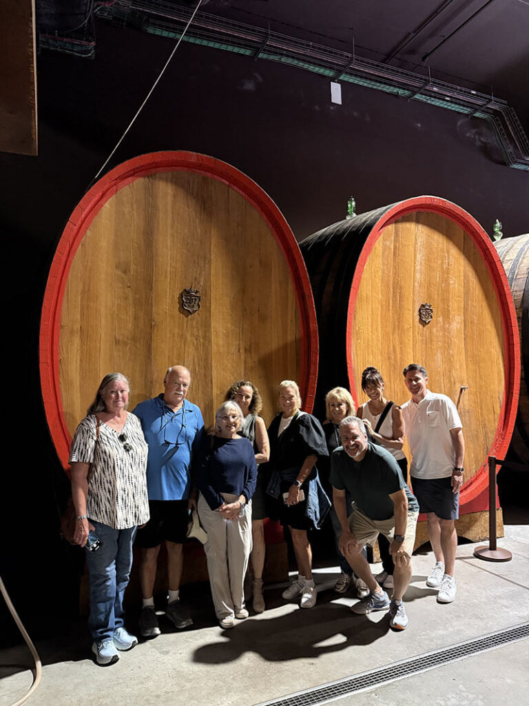 Tour-Group-at-Tuscany-Winery-in-front-of-wine-barrels